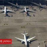 女が飛行機のエンジンに小銭を投げ入れる